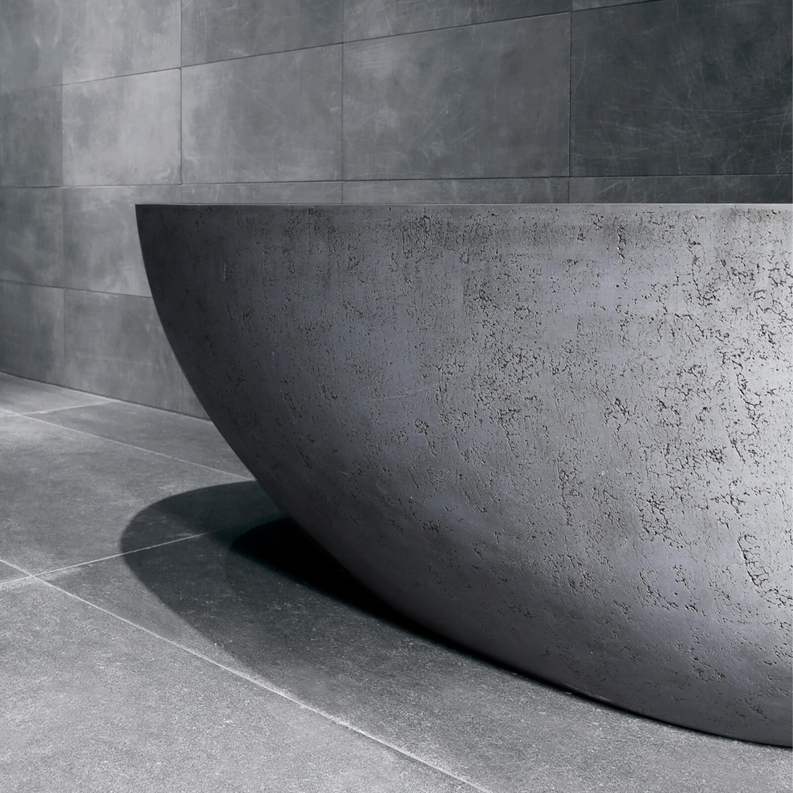 Artistic concrete bathtub with an industrial finish and crack patterns